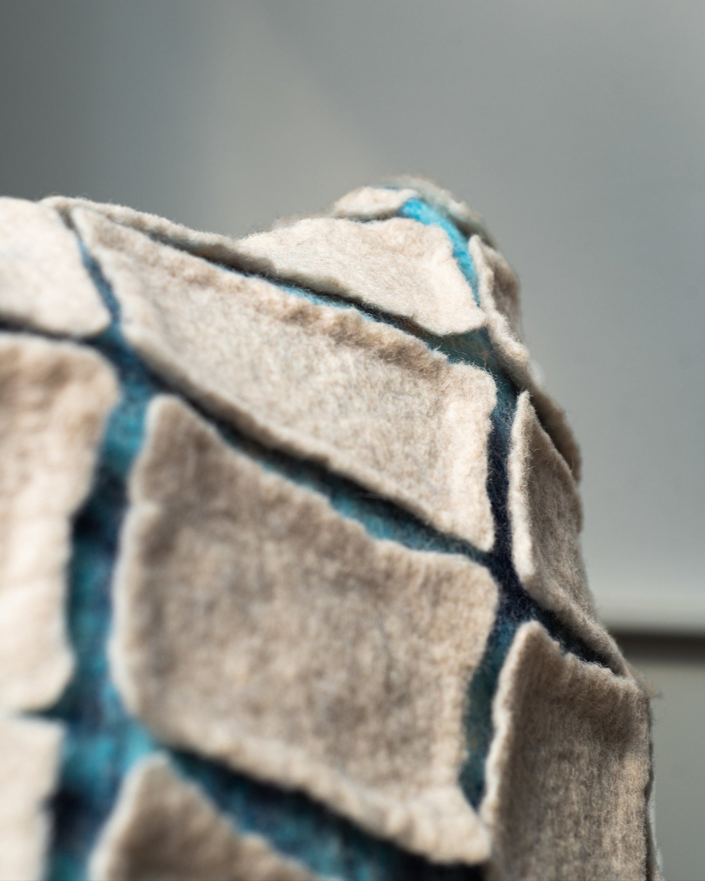 Geometric felt pillow inspired by cracked soil – contemporary textile art by The Tuftista